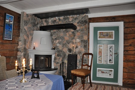 Nordstua har peis og plass til ti .R�e t�mmervegger med dekorerte d�rer fra lokalhistorisk tid.